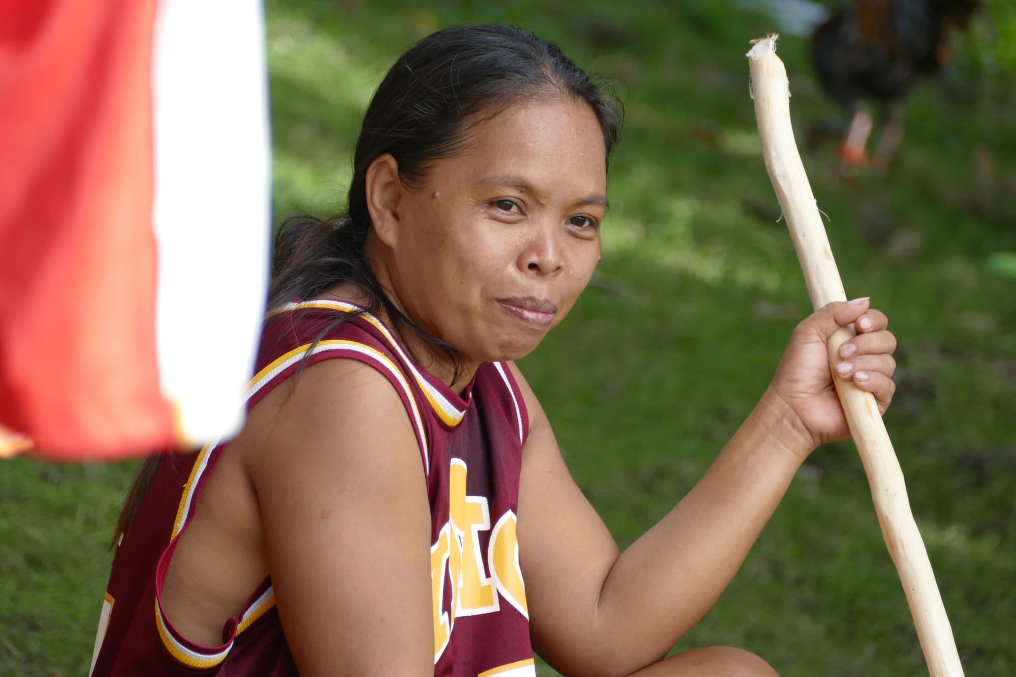 A woman looks up from splitting bamboo